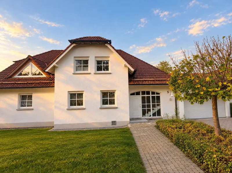 Weißes Wohnhaus mit Rasen und Weg zur Haustür